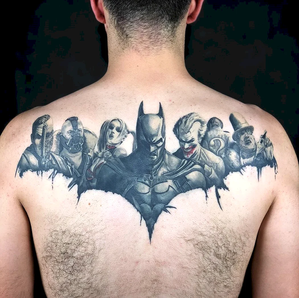 A close up of a man with a batman tattoo on his chest